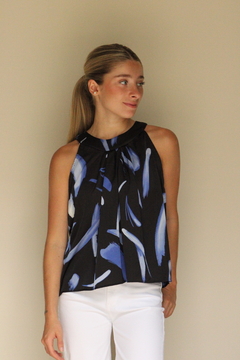 Blusa Sia de color negro con estampado azul, modelo femenino posando frente a un fondo claro.