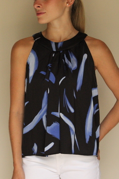 Blusa Sia de color negro con estampado en tonos azules, modelo sin mangas, usada por una mujer.