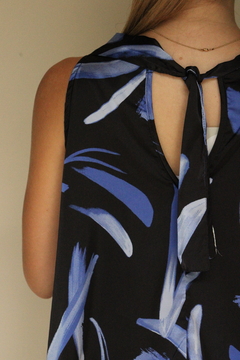 Vista posterior de la blusa Sia con estampado azul y negro, destacando el lazo en la parte superior.