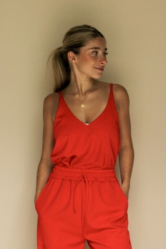 Musculosa Turmalina de color rojo, con tirantes finos y escote en V, combinada con pantalones del mismo tono.