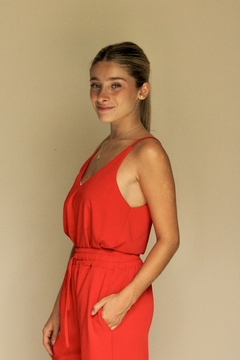 Modelo luciendo una musculosa turmalina roja, con tirantes delgados y un diseño elegante.