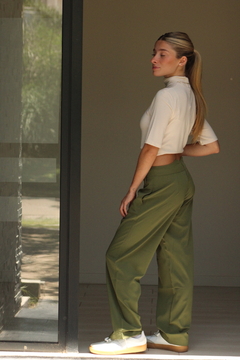 Pantalón Khalo en color verde olivo, modelo femenino posando de perfil con una blusa corta y zapatillas blancas.