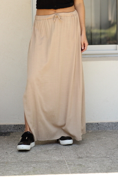 Pollera larga de lino color beige, con cintura elástica, combinada con zapatillas negras.