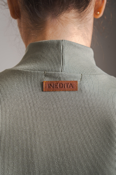 Vista trasera de una polera LEXIE con etiqueta INEDITA en color marrón.