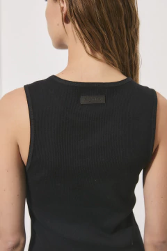 Vista trasera de una musculosa negra de mujer con etiqueta en la parte superior.