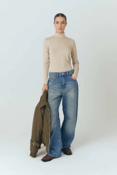 Polera clásica, con mangas largas. modelo femenina posando con jeans desgastados