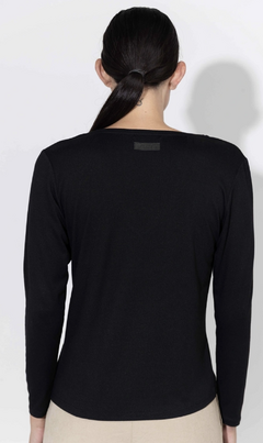 Vista posterior de la remera EMILY de color negro, con mangas largas y etiqueta en la parte superiormarca Inedita.
