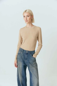 Remera Laurel de color beige, con un diseño de manga larga y textura acanalada, vista frontal de una mujer con cabello corto.