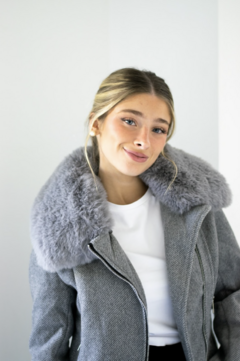 Campera gris corte medio, muy abrigada. Detalle de piel sintética en el cuello y cierre delantero con cremallera.
