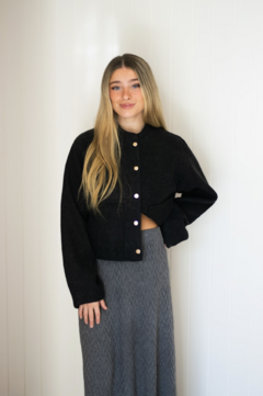 Campera ancha estilo cuadrada, corte medio. Con bolsillos a los laterales y cierre delantero con botones.