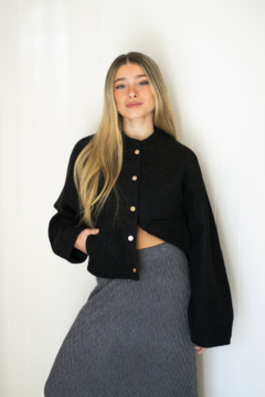Campera ancha estilo cuadrada, corte medio. Con bolsillos a los laterales y cierre delantero con botones.