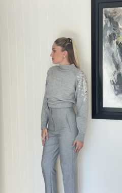 Sweater largo con diseño de strass en los hombros que caen por la manga. Cuello alto