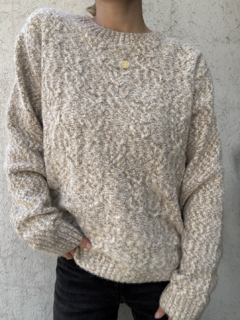Sweater tejido color arcilla con diseño de trenzas y cuello redondo. Textura peludita, corte largo.
