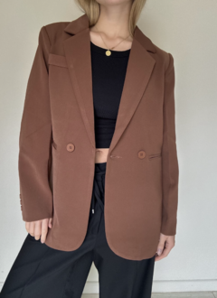 Blazerlargo,  color chocolate con botones﻿, y falso bolsillo. Corte largo y hombros elegantes