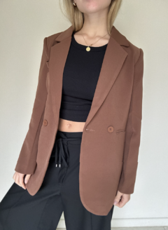 Blazerlargo,  color chocolate con botones﻿, y falso bolsillo. Corte largo y hombros elegantes
