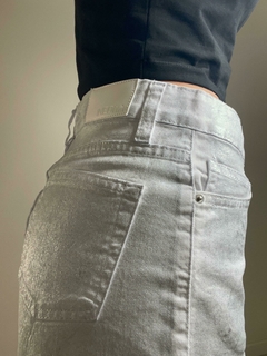 Shorts plateados de denim con costuras visibles y etiqueta en la parte trasera.