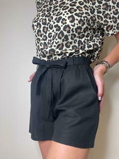 Shorts de color negro con cinturón, combinados con una blusa de estampado de leopardo.