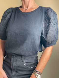 Remera Ness de color gris oscuro con mangas abullonadas y detalles de bordado en las mangas.