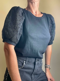 Remera Ness de color negro con mangas abullonadas y detalles de bordado en las mangas.