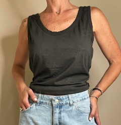 Musculosa Boho negra con estampado de estrellas brillantes, usada por una mujer que lleva jeans cortos.