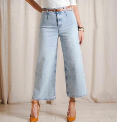 Jean de mezclilla claro con cinto, estilo wide-leg, combinado con zapatos de tacón naranja.