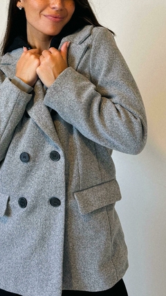 Tapado de paño corte medio, estilo elegante-sport. Combinación de tapado con solapa y botones, campera interior con cierre conectada con la capucha (ambas desmontables). Interior 100% peludo y calentito