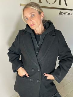 Tapado de paño corte medio, estilo elegante-sport. Combinación de tapado con solapa y botones, campera interior con cierre conectada con la capucha (ambas desmontables). Interior 100% peludo y calentito