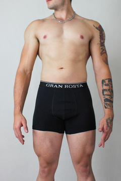 Hombre usando bóxer negro gran rosta ajustado con cintura elástica y diseño ergonómico. Ropa interior masculina de algodón y elastano para comodidad y estilo.