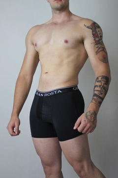 Hombre vistiendo bóxer negro deportivo ajustado de alta calidad, ideal para brindar comodidad y soporte. Ropa interior masculina moderna y ergonómica.