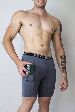 Licra deportiva para hombre en color gris, con diseño ergonómico y bolsillo lateral para mayor practicidad. Perfecta para correr, entrenar y actividades deportivas.
