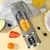Espremedor portátil de carregamento USB com frutas picadas e gelo no interior, sobre uma superfície amarela.