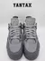 Vista frontal de las zapatillas Jordan 4 SE Paris Olympics Wet Cement en color gris.