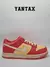 Zapatillas Nike Dunk Low en colores crema y fresa, vistas lateralmente.