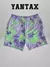 Shorts de Puma x MELO en diseño toxic AOP, color verde y morado, con logo distintivo.