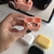 Auriculares inalámbricos Bluetooth TWS en colores pastel rosa, amarillo, blanco y negro, sobre una superficie blanca, junto a un teclado.