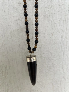 Collar con cuerno de asta , el cuerpo del mismo esta confeccionado con piedras obsidianas naturales y piedra ojo de tigre natural de 6mm. Cierre en mosqueton de acero quirurgico. 