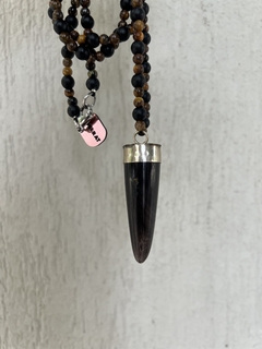 Collar con cuerno de asta , el cuerpo del mismo esta confeccionado con piedras obsidianas naturales y piedra ojo de tigre natural de 6mm. Cierre en mosqueton de acero quirurgico. 
