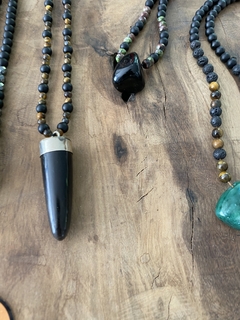 Collar con cuerno de asta , el cuerpo del mismo esta confeccionado con piedras obsidianas naturales y piedra ojo de tigre natural de 6mm. Cierre en mosqueton de acero quirurgico. 