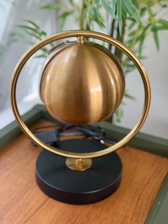Abajur de metal dourado e preto na internet