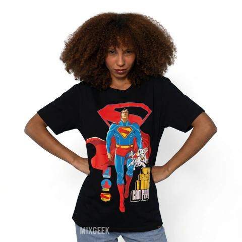 Camiseta preta unissex com estampa colorida do Superman e seu cão Krypto, modelo com cabelo cacheado posando com as mãos na cintura