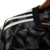 Detalhe da camisa Ajax Third 23/24, mostrando as listras e o tecido preto com padrão geométrico.