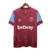 Camisa torcedor do West Ham, modelo 23/24, na cor vermelha com detalhes em azul claro, logo da Umbro e estampa "betway".