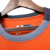 Detalhe do colarinho da camisa Third Inter de Milão 23/24, na cor laranja, com a marca Nike.