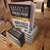 Livro "Não Faça Networking" de Marcus Vinicius Freire, empilhado em uma mesa de madeira.