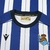 Camisa do Real Sociedad Torcedor I Titular - Masculina 2025/26 Macron - Zeus Mantos | Futebol & Estilo