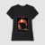 Camisa feminina preta com estampa temática de Halloween, apresentando um gato preto em frente a uma janela com uma caveira e um livro.