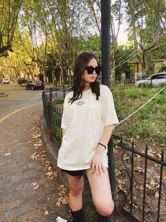 Modelo posando con remera oversize Strach 'Classic' beige unisex - Estampado limitado.