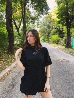 Modelo posando con remera oversize Strach 'Classic' negra unisex - Estampado limitado.