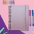 Caderno Smart pequeno A5 com folhas reposicionáveis, cercado por clipes coloridos e canetas.