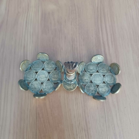 Cestinha feita com moedas de 50 centavos de 1956, incluindo uma Figa de Madeira